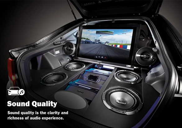 Trunk of a car converted into an advanced entertainment system with multiple Rockford Fosgate subwoofers, amplifiers, and a large screen showing a racing game; text reads “Sound Quality – Sound quality is the clarity and richness of audio experience.”