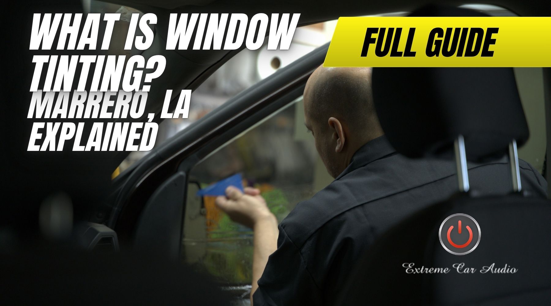 A man applies window tint to a car door using a blue tool, viewed from the passenger seat. Large bold text over the image reads, "What Is Window Tinting? Marrero, LA Explained," with a yellow banner that says "Full Guide" and a logo reading "Extreme Car Audio" at the bottom right.