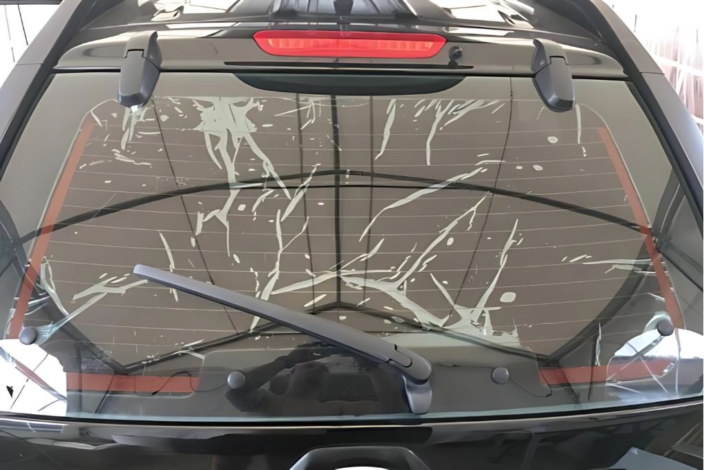 Rear view of a black SUV with visibly damaged window tint showing severe bubbling, peeling, and streaking. The image illustrates a key visual cue in the topic How to Tell If Your Tint Needs Replacing.